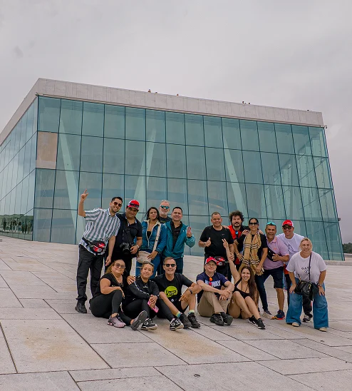 Grupo de viajeros frente a un edificio en la galería de Moto Travel Tours
